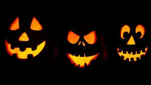 Three glowing jack-o'-lanterns in the dark